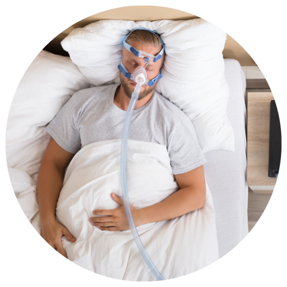 Man wearing CPAP mask in bed.